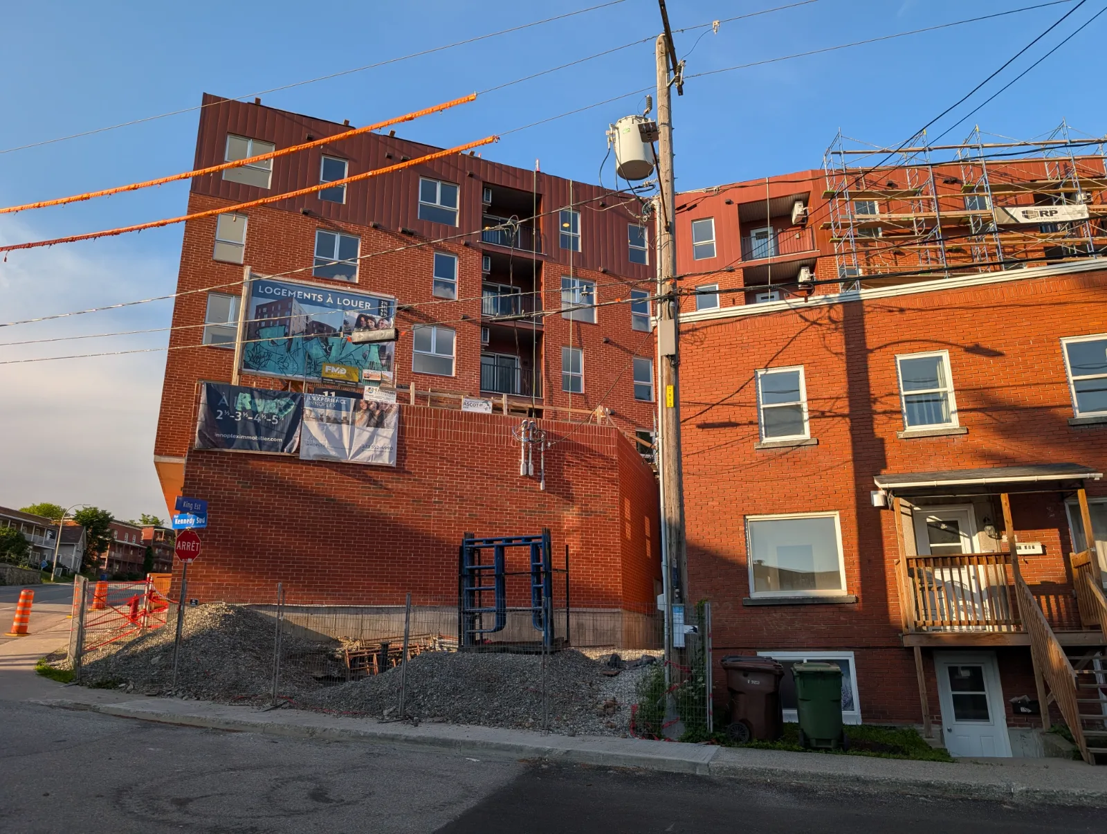 Le Citéa de six étages avec son mur aveugle dominant un petit immeuble au coin de King Est et Kennedy Sud
