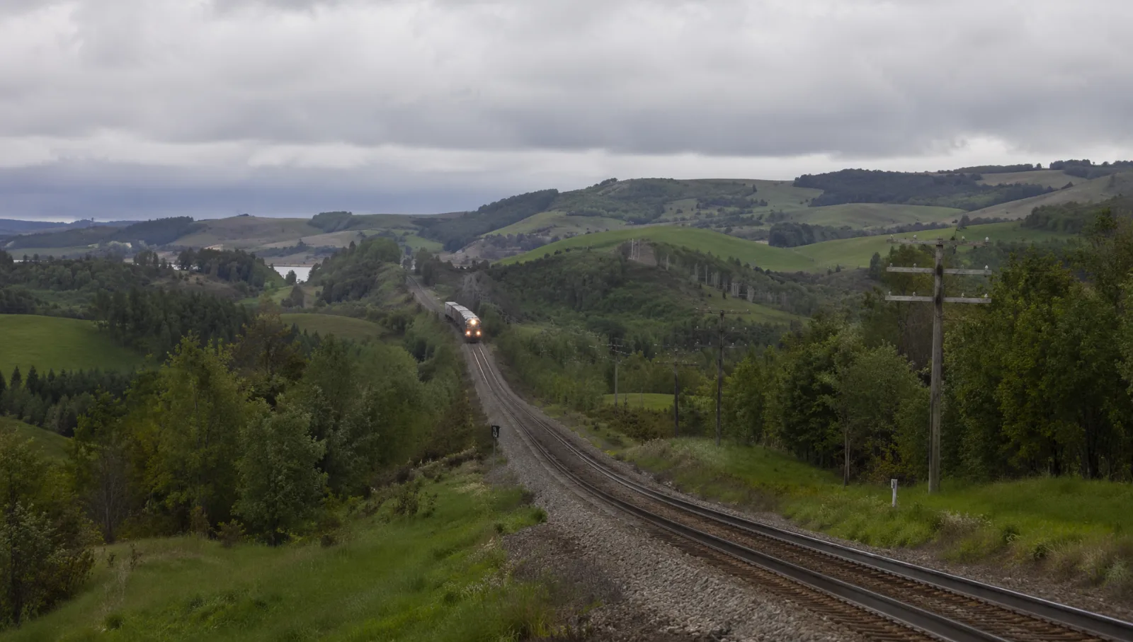 Voie ferrée coupant à travers un paysage rural en sursis
